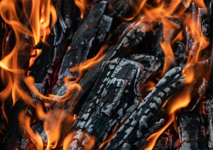 Dei pezzi di legno semicarbonizzato stanno bruciando