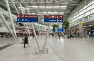 L'interno di uno dei terminal dell'Aeroporto Internazionale di Dusseldorf, con negozi, insegne e persone