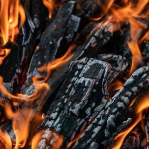 Dei pezzi di legno semicarbonizzato stanno bruciando