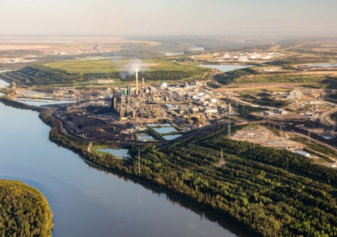 Vista aerea dello stabilimento di raffinazione del petrolio di Fort McMurray, in Canada, sulle rive del fiume, con la natura circostante