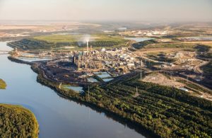 Vista aerea dello stabilimento di raffinazione del petrolio di Fort McMurray, in Canada, sulle rive del fiume, con la natura circostante