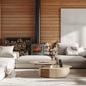 Salotto di una casa di montagna con pareti in legno, grande finestra che dà su un panorama innevato, stufa a legna, divani chiari, tavolino realizzato da un tronco di legno e grande quadro astratto sui toni del bianco alla parete