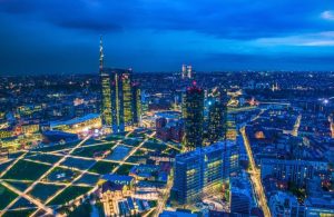Vista dall'alto di Milano di notte, con i palazzi illuminati e i nuovi grattacieli