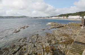 Panorama di un tratto di costa dell'Isola di Man, nel Regno Unito, con gli edifici della cittadina di Douglas, la capitale, affacciati sul mare