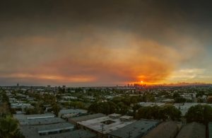 Il fumo dei devastanti incendi di Pacific Palisades e Hollywood Hills copre il cielo sopra il panorama dello skyline di Los Angeles al tramonto