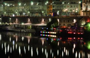 Vista notturna sui Murazzi di Torino, con le luci dei locali che si riflettono sul fiume