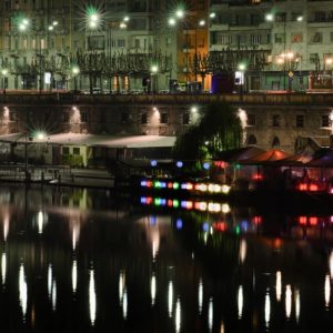 Vista notturna sui Murazzi di Torino, con le luci dei locali che si riflettono sul fiume